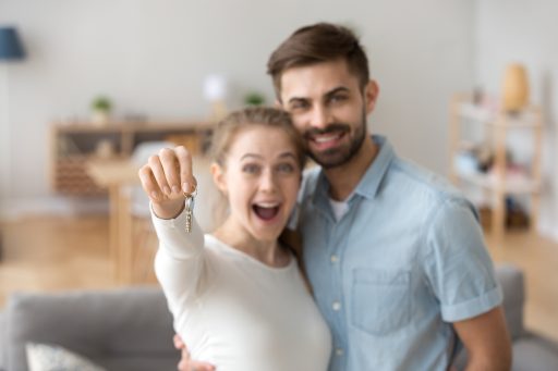 Portrait,Of,Happy,Millennial,Couple,Hug,Holding,Key,To,Own