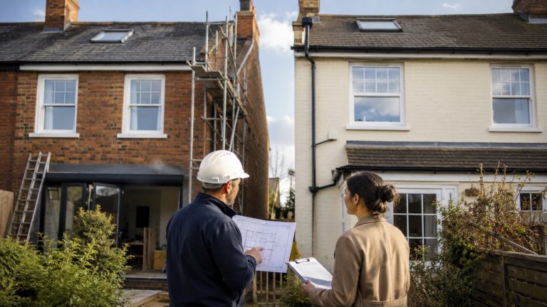Party Wall Act 1996 Explained for UK Homeowners Renovating Party Wall Act 1996 explained with surveyor and homeowner reviewing renovation plans beside adjoining UK houses