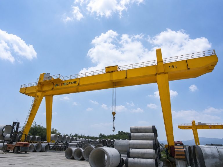 Types of gantry cranes operating in an industrial concrete pipe storage yard