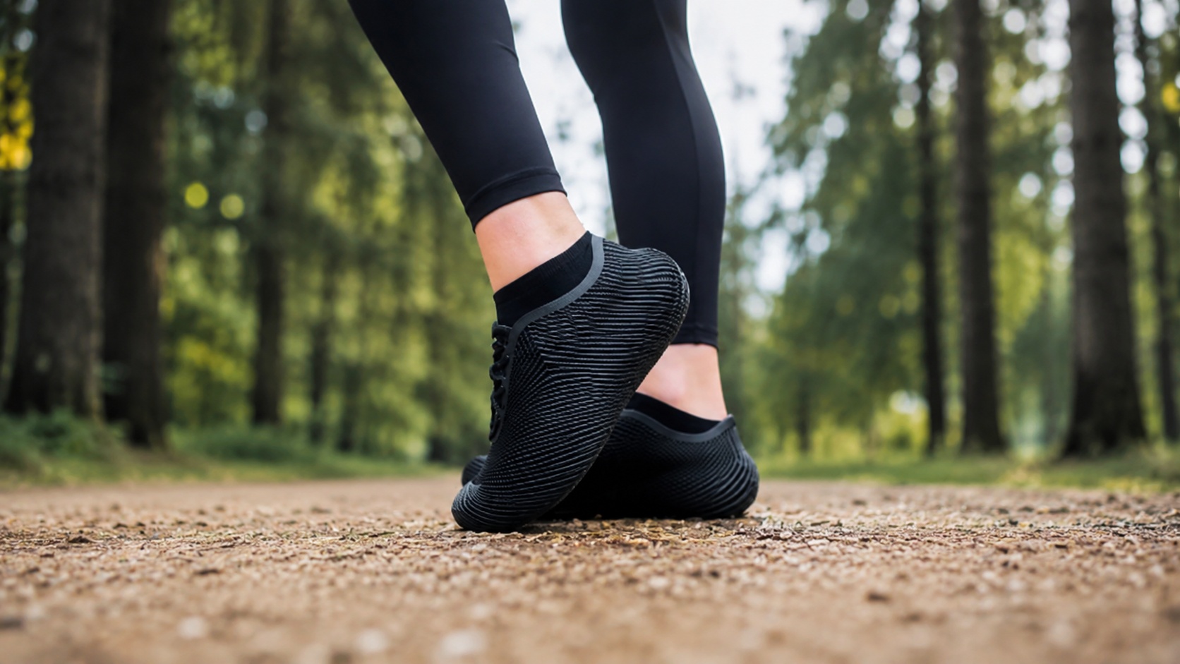 Black 3D printed sneakers worn on a forest walking trail